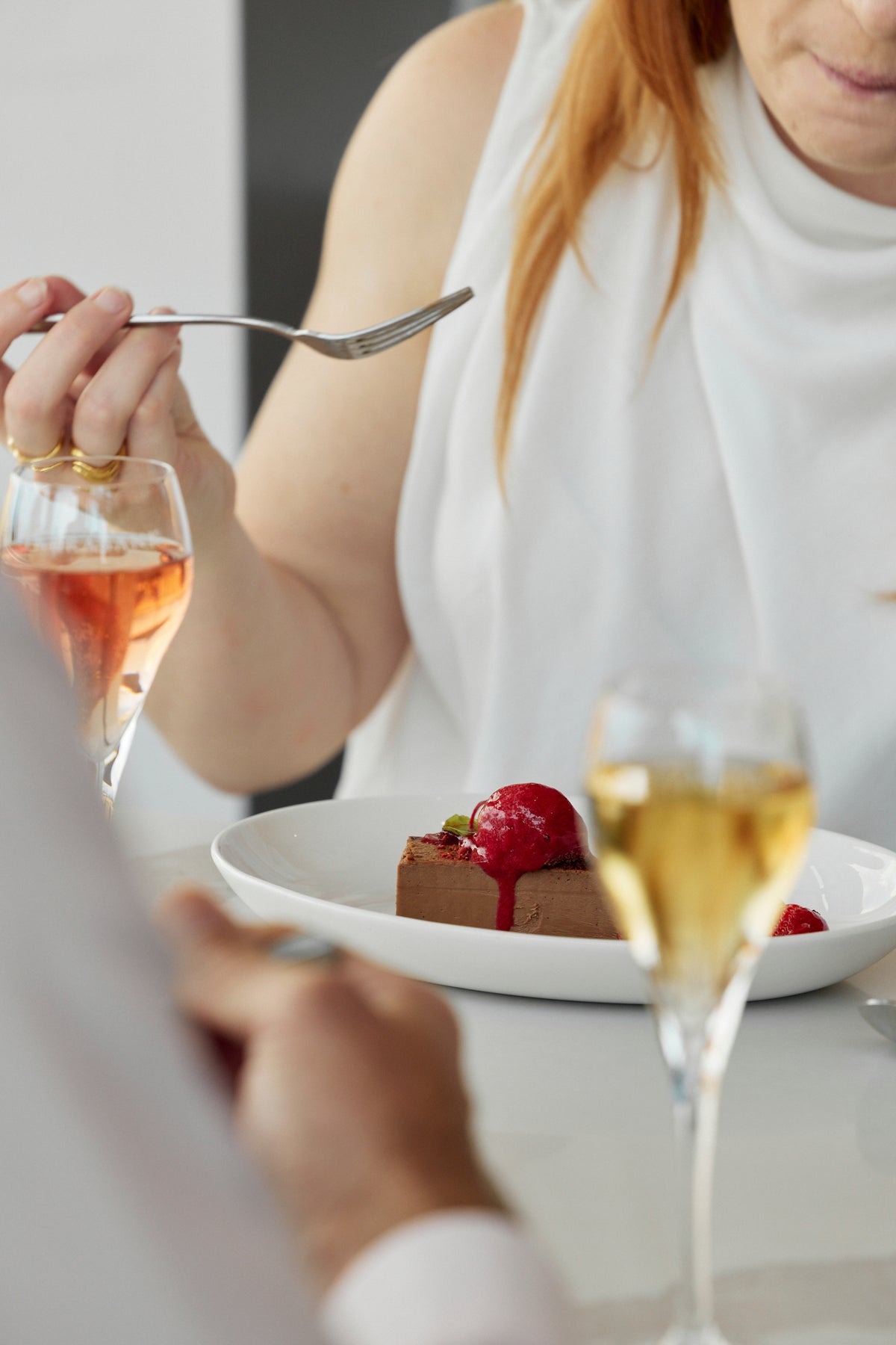 Guest eating dessert with glasses of wine and champagne on the table